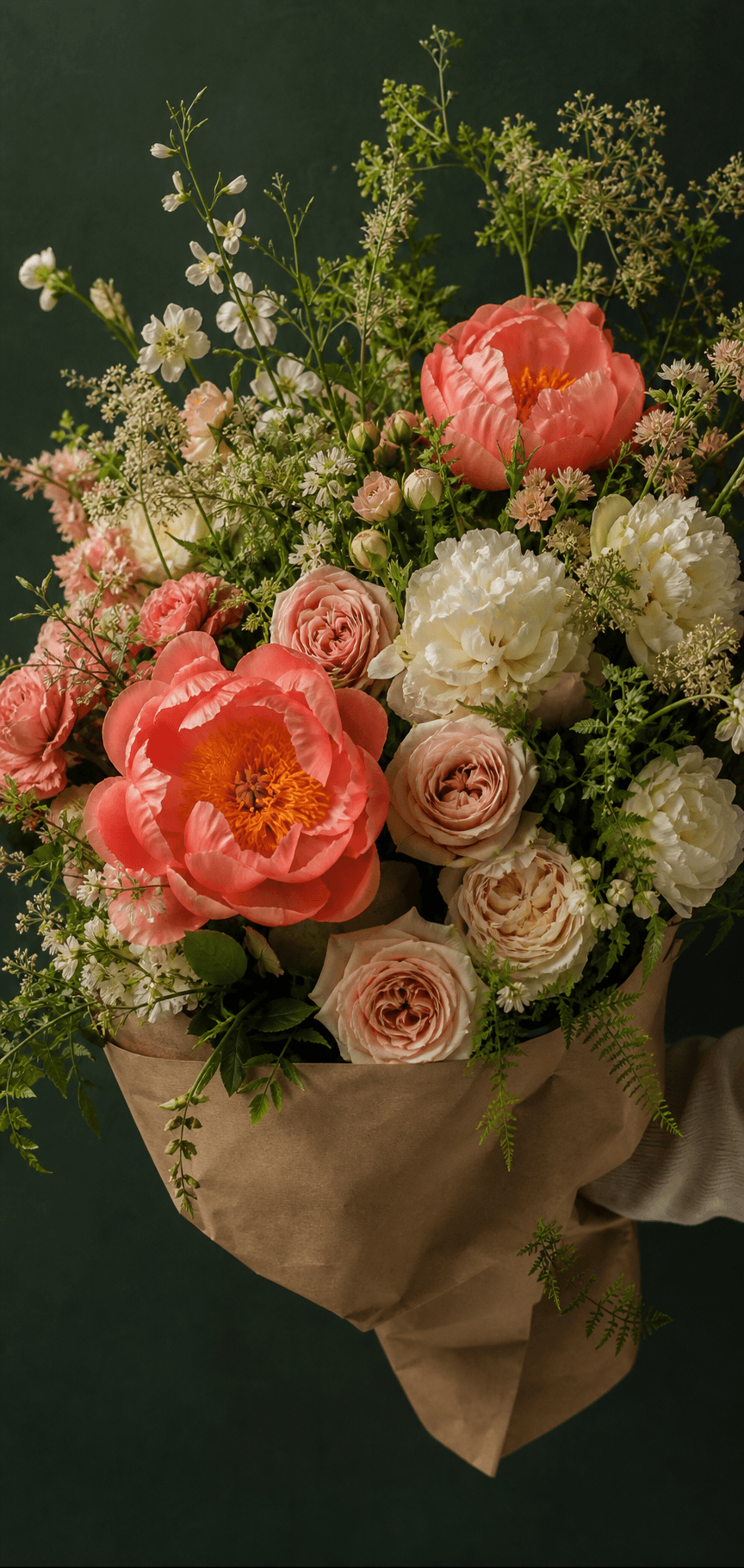 Coral, blush, and ivory seasonal flowers gathered in a garden-style arrangement